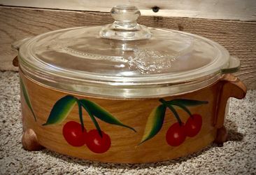 vintage Pyrex casserole dish in a hand-painted wooden holder with a cherry motif