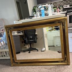     This is a large, ornate, antique-style gold-framed mirror, possibly in a Victorian Style