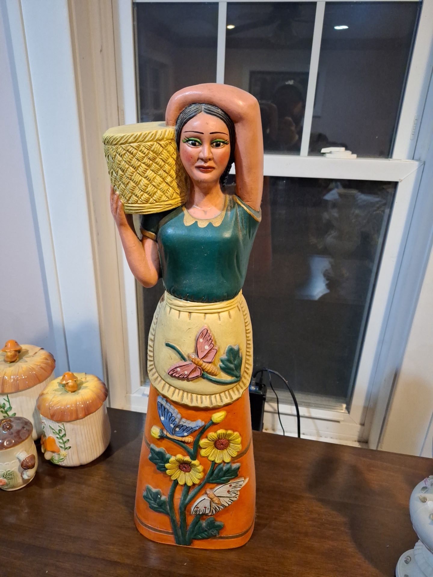 Hand-painted ceramic folk art figurine of a woman with a basket