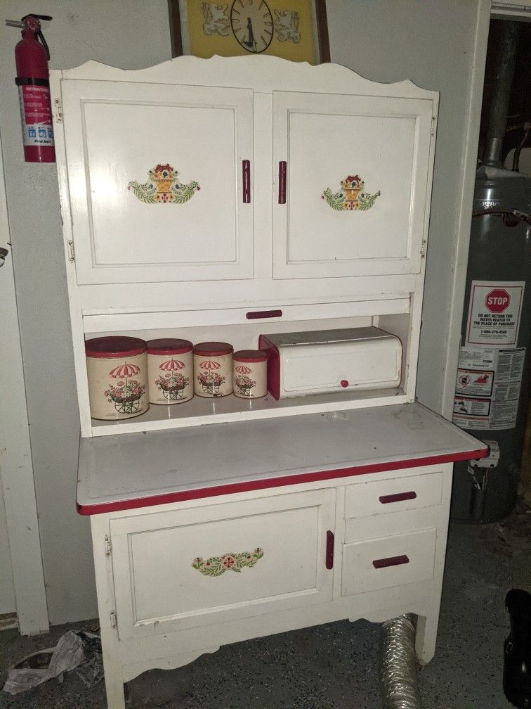Gorgeous rare Hoosier cabinet. White trimmed in red porcelain top. Comes with a metal canister set that matches and bread box. 