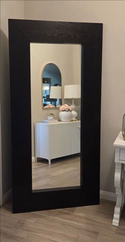 Large floor mirror with a wide dark brown wood-grain frame. This leaning mirror has a rectangular shape and a beveled-style frame. Used, in good condi