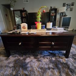 This is a dark wood coffee table with two drawers