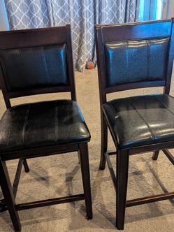 4 black and brown counter height chairs