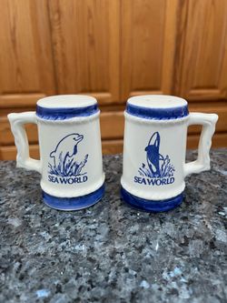 Vintage 1974 Mugs Souvenir Sea World Salt & Pepper Shaker Set.  Made of Ceramic.  With cork plastic stoppers .  On the bottom foil sticker says Japan.