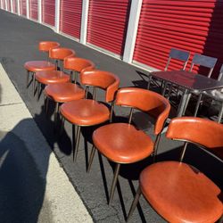 $50 each / $50 cada una /four modern-style dining chairs with orange faux leather upholstery