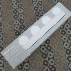 THIS IS FOR A NEW IN BOX BROOKSTONE REMOTE CONTROLLED VANITY LIGHT can be used on any surface  Remote-controlled vanity light with 4 LED globes. Even 