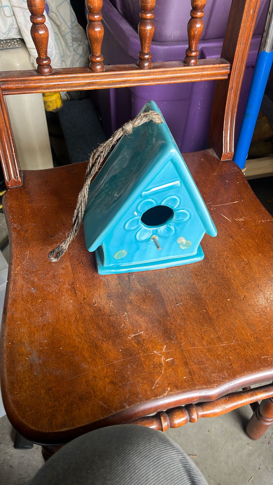This is a Rae Dunn ceramic birdhouse in blue or aqua with a jute cord for hanging.