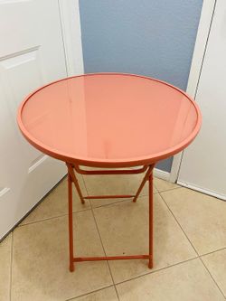 Round Metal Folding Outdoor Bistro Table In A Vibrant Coral Or Flamingo Pink Shade.