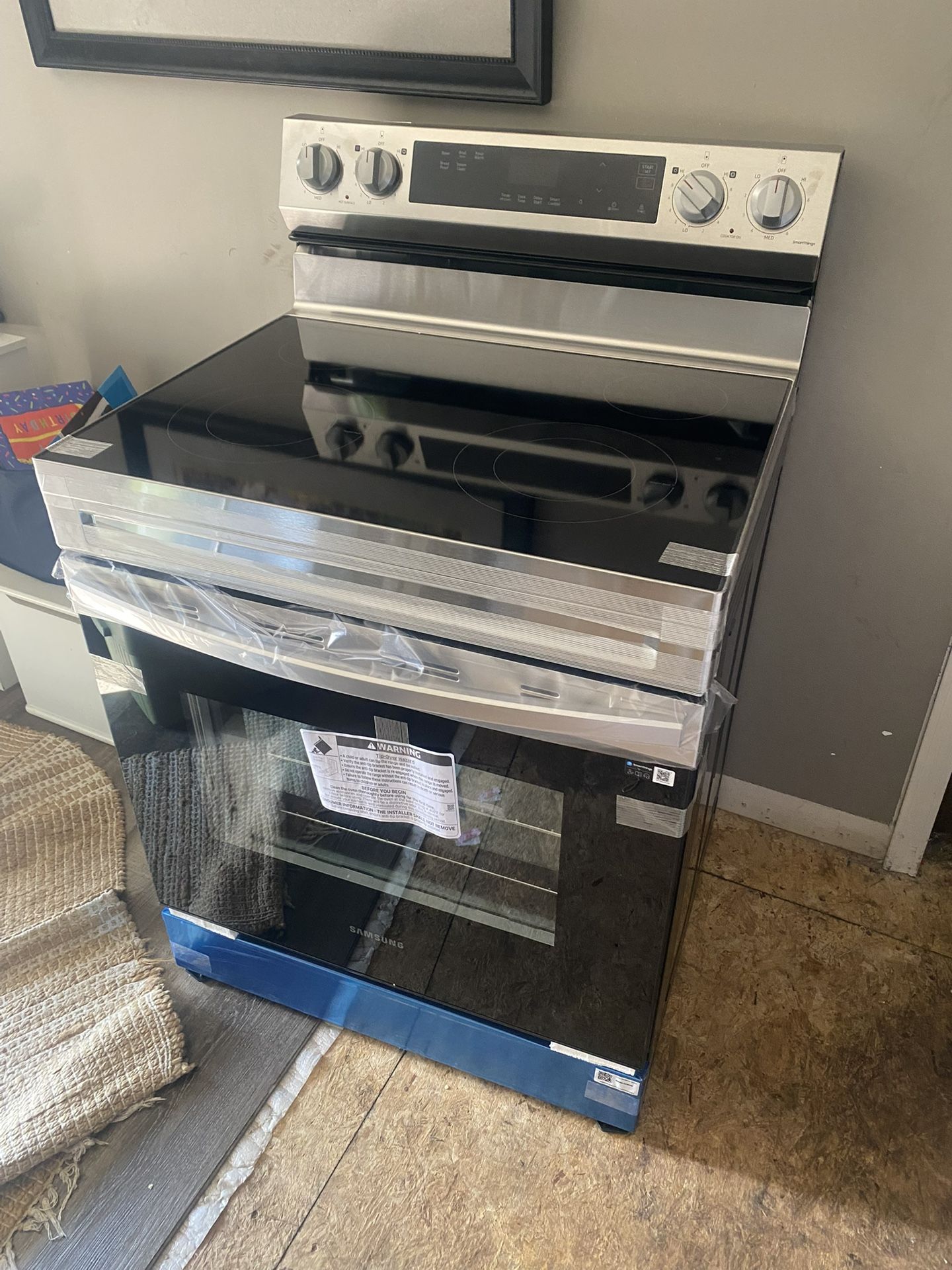 Smart Freestanding Electric Range, model NE63A6751SS/AA. This appliance features a stainless steel design with a black glass cooktop and oven door. It