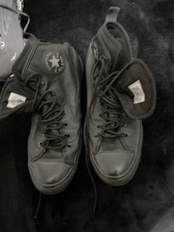 black high-top shoes are Converse Chuck Taylor