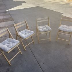 Four fold up wooden chairs