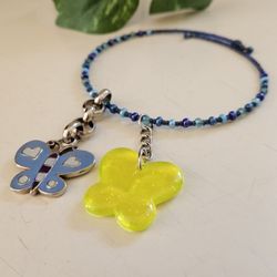 Dainty Blue Beaded Expandable Choker Necklace with 2 - 2" Keychain Butterfly Charm Pendants. One silver and blue enamel butterfly and one yellow plas