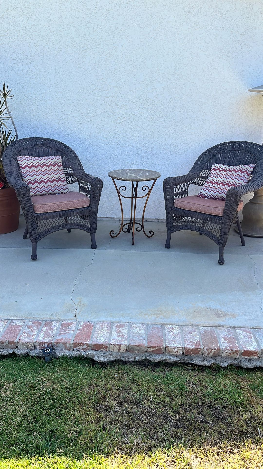 Two wicker chairs with marble top table