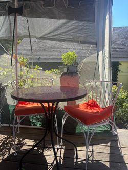 Mosaic table with two matching rod iron chairs