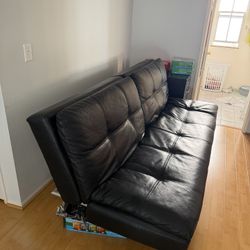 black faux leather tufted futon