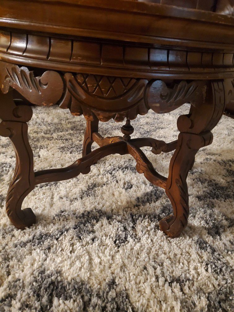 Antique table with carvings & glass top.