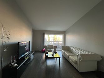 High-end living room furniture: White Tufted Leather Chesterfield Sofa and armchair with leather barstools and black glass coffee table