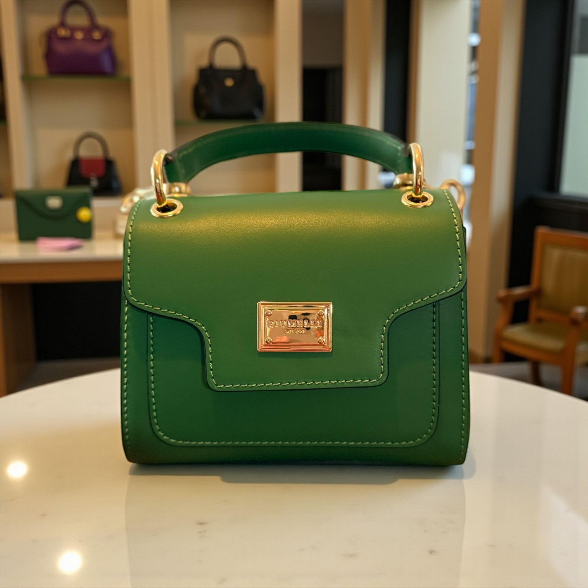 A contemporary green leather Piumelli Milano handbag with gold hardware.