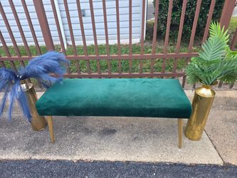 Green velvet bench with gold legs and tw0 decorative flowers