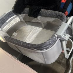 Portable bassinet with music box and light