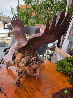 The bald eagle sculpture is hand-carved from wood.