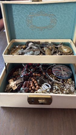 Jewelry box full of religious items in an antique jewelry box