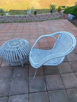 White wicker patio chair and wicker foot stool