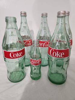6 Coca Cola Bottles with lids
