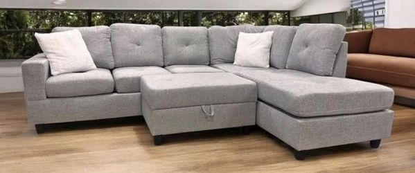 Rocket Gray Fabric Reversible Sectional with Cup Holder and Storage Ottoman . Brand New .