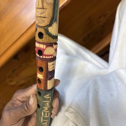 This object is a hand-carved wooden flute, a common type of folk art souvenir from Guatemala