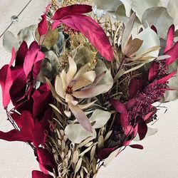 A red vase with real dried flower