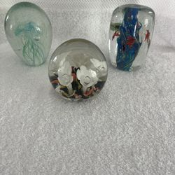Three Glass Paperweights With Aquatic And Floral Themes