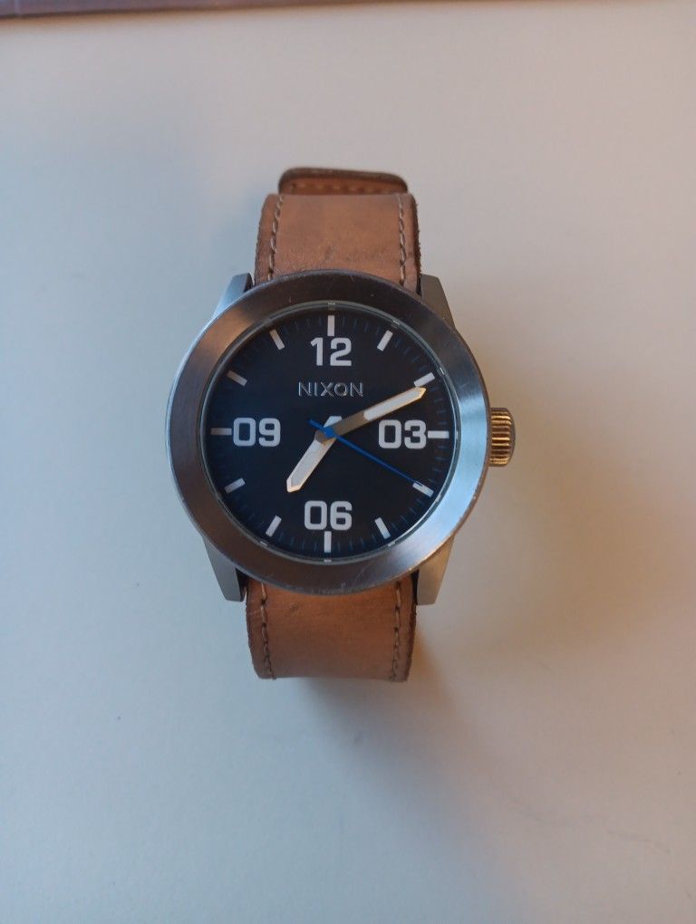 The Nixon Private Black Dial Stainless Steel Leather Quartz Men's Watch A049-1602 features a sleek black stainless steel case with a scratch-resistant