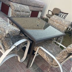A Beautiful Outdoor Table With Four Chairs 