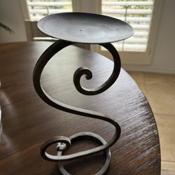 Decorative metal candle holder with swirl design.