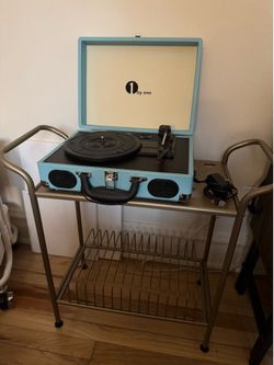 Light teal record player and brass record stand