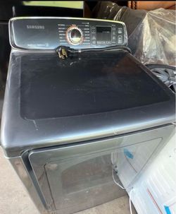 Blue Samsung electric dryer with a glass door and digital control panel. Multiple cycle options including Heavy Duty, Bedding, Quick Dry, and Steam Sa