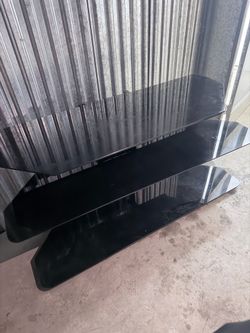 Modern black tempered glass TV stand with 3 shelves.