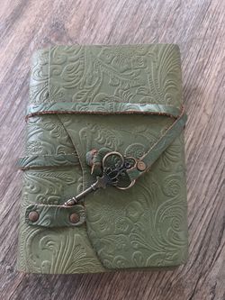 green leather bound paper notebook