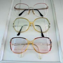 3 pair of vintage eye glass frames.  Two have prescription lenses in them and One does not have any lenses
