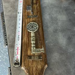 This is a vintage Spanish Revival key plaque featuring two decorative keys on a wooden board.  