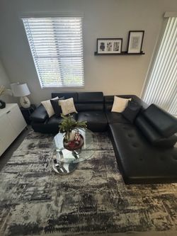 Black synthetic leather sectional sofa with cushions