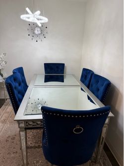 Silver dining table with a set of 6 dark blue chairs