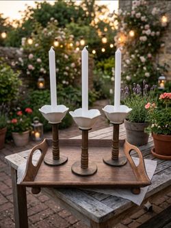 White flower-petal ceramic taper candle holders supported turned dark-wood stems