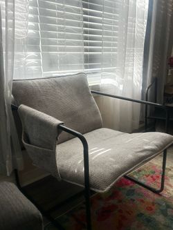 Grey cushioned chair with phone holder