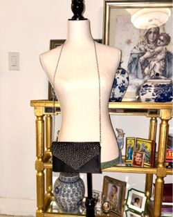 The envelope-style party bag is mainly manufactured by the Nodykka brand, with a geometric flap adorned with rhinestones and a silver chain for carryi