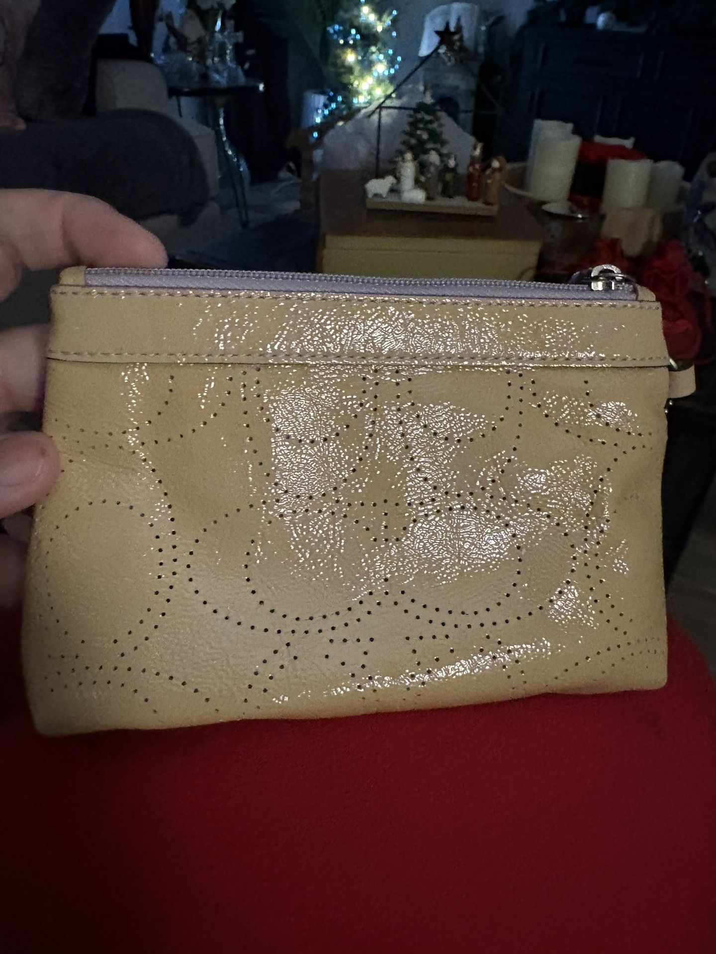 Coach patent leather perforated signature C wristlet.