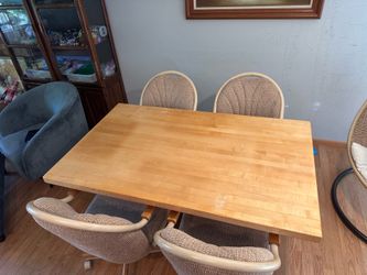 Maple wood dining table and 4 swivel chairs on wheels