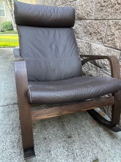 IKEA POÄNG Rocking Chair with a dark brown leather cushion cover and a brown-stained wood frame.