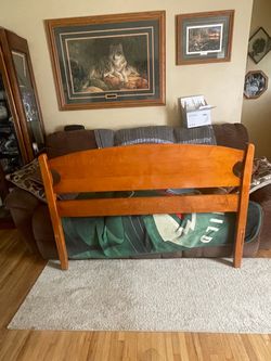Full size wood bed frame has side boards and middle
